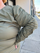 Load image into Gallery viewer, Close up view of the ruched long sleeve puff shoulder detail of a size 4 Fashion to Figure army green all-over ruched long sleeve midi dress with keyhole bust detail on a size 22/24 model. The photo is taken outside in natural lighting.
