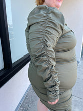Load image into Gallery viewer, Close up view of the ruched long sleeve detail of a size 4 Fashion to Figure army green all-over ruched long sleeve midi dress with keyhole bust detail on a size 22/24 model. The photo is taken outside in natural lighting.
