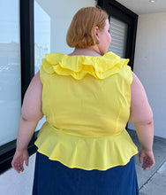 Load image into Gallery viewer, Back view of a size 4 Fashion to Figure x Gabrielle Union collab bright yellow ruffled wrap blouse styled with a denim skirt on a size 22/24 model. The photo is taken outside in natural lighting.
