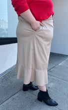 Load image into Gallery viewer, Additional side view showing off the pocket of a size 24/26 Ulla Popken khaki maxi skirt with drawstring waist and ruffle hem styled with a red sweater and black boots on a size 22/24 model. The photo is taken outside in natural lighting.
