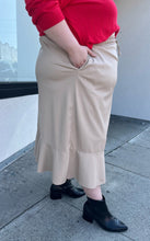 Load image into Gallery viewer, Additional side view showing off the pocket of a size 24/26 Ulla Popken khaki maxi skirt with drawstring waist and ruffle hem styled with a red sweater and black boots on a size 22/24 model. The photo is taken outside in natural lighting.
