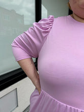 Load image into Gallery viewer, Close view of the puffed shoulder of a size 2X Who What Wear light pink puff sleeve maxi dress with a ruffled hem on a size 22/24 model. The photo is taken outside in natural lighting.
