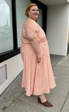 Load image into Gallery viewer, Full-body side view of a size 5X WRAY NYC orange and white checkered windowpane tank maxi dress with tie belt styled with brown mules on a size 22/24 model. The photo is taken outside in natural lighting.
