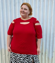 Load image into Gallery viewer, Front view of a size 30/32 Ashley Stewart red cut-out blouse with shoulder, sleeve, and bust cut-outs on a size 22/24 model. The photo is taken outside in natural lighting.
