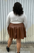 Load image into Gallery viewer, Back view of a size 18/20 Eloquii off-white longline sweater with side slits, a tie belt, subtle puff sleeves, and a v neck styled tucked into a brown pleather mini skirt on a size 18/20 model. The photo is taken outside in natural lighting.

