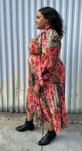 Load image into Gallery viewer, Full-body side view of a 18 Rachel Parcell pink, coral, brown, and cream patchwork floral pattern with pleated skirt, pussy bow, and bishop sleeve styled with black boots on a size 18/20 model. The photo is taken outside in natural lighting.
