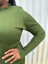 Load image into Gallery viewer, Close up view of the all-over smocking of a size XXL Rachel Parcell forest green all-over smocking long sleeve midi dress with mock neckline and ruffle hem on a size 14/16 model. The photo is taken outside in natural lighting.

