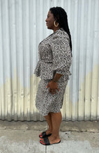 Load image into Gallery viewer, Full-body side view of a size 12/14 Alexis Fashion Inc. vintage white and black abstract pattern sheath dress with v-neck and peplum details styled with black heels on a size 14/16 model. The photo is taken outside in natural lighting.
