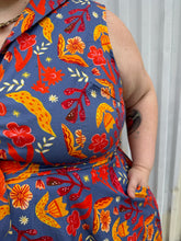 Load image into Gallery viewer, Close up view of the collar and belt of a size 3X Miss Lulo blue, yellow, and red mixed floral print collared midi dress with fabric buttons and a matching belt on a size 22/24 model. The photo is taken outside in natural lighting.
