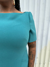 Load image into Gallery viewer, Close view of the structured cap sleeve and boatneck a size 16 Zac Posen via 11 Honoré teal boatneck sheath dress on a size 14/16 model. The photo is taken outside in natural lighting.
