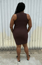 Load image into Gallery viewer, Full-body back view of a size 14 Pretty Little Thing dark brown ribbed cut-out mini bodycon dress styled with black slides on a size 14/16 model. The photo is taken outside in natural lighting.
