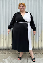 Load image into Gallery viewer, Additional full-body front view of a size 22 Eloquii black and white collared wrap dress styled with black slides on a size 22/24 model. The photo is taken outside in natural lighting.
