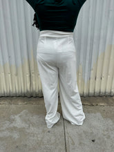 Load image into Gallery viewer, Back view of a pair of size 16 Boohoo white wide leg trousers styled with a dark teal long sleeve tee on a size 14/16 model. The photo is taken outside in natural lighting.

