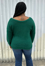 Load image into Gallery viewer, Back view of a size 14/16 Eloquii emerald green twist-front cropped sweater with tummy cut-out styled with medium wash denim on a size 14/16 model. The photo is taken outside in natural lighting.

