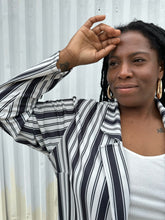 Load image into Gallery viewer, Close up view of the collar &amp; sleeve of a size 18 Pink Clove black and white vertical striped collared duster styled open over a white tee on a size 14/16 model. The photo is taken outside in natural lighting.
