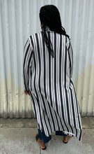 Load image into Gallery viewer, Full-body back view of a size 18 Pink Clove black and white vertical striped collared duster styled open over a white tee, dark jeans, and black slides on a size 14/16 model. The photo is taken outside in natural lighting.
