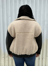 Load image into Gallery viewer, Back view of a size XXL Rachel Parcell black and ivory shearling zip-up bomber jacket styled unzipped over a white tied-up tee and medium wash denim on a size 14/16 model. The photo was taken outside in natural lighting.
