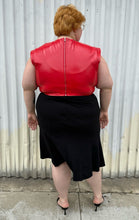 Load image into Gallery viewer, Full-body back view of a size 26 Lane Bryant black handkerchief hem midi skirt with zipper closure styled with a red pleather sleeveless crop top and black kitten heels on a size 22/24 model. The photo is taken outside in natural lighting.
