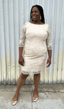 Load image into Gallery viewer, Full-body front view of a size 16 Eliza J off-white embroidered and sequined boatneck midi dress with three-quarter length sleeves styled with gold flats on a size 14/16 model. The photo is taken outside in natural lighting.
