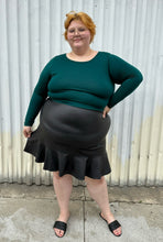 Load image into Gallery viewer, Full-body front view of a size 18/20 Eloquii dark teal long sleeve t-shirt styled over a black pleather mini skirt and black slides on a size 22/24 model. The photo is taken outside in natural lighting.
