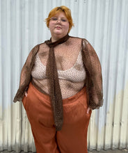 Load image into Gallery viewer, Additional front view of a size 22/24 Eloquii dark brown sheer puff sleeve pussybow blouse styled tucked into a pair of rust colored silky pants on a size 22/24 model. The photo is taken outside in natural lighting.
