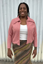 Load image into Gallery viewer, Front view of a LIVD Apparel size 1X dusty rose fuzzy collared crop jacket styled open over a white ribbed tank and earth tone striped skirt on a size 14/16 model. The photo is taken outside in natural lighting.
