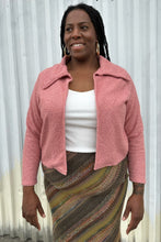 Load image into Gallery viewer, Additional front view of a LIVD Apparel size 1X dusty rose fuzzy collared crop jacket styled open over a white ribbed tank and earth tone striped skirt on a size 14/16 model. The photo is taken outside in natural lighting.

