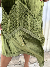 Load image into Gallery viewer, Close up view of the embroidered and woven textured details of a size 12/14 Vestiaire Collective forest green crushed velvet handkerchief hem midi skirt with mixed materials woven and embroidered in on a size 14/16 model. The photo is taken outside in natural lighting.
