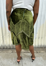 Load image into Gallery viewer, Back view of a size 12/14 Vestiaire Collective forest green crushed velvet handkerchief hem midi skirt with mixed materials woven and embroidered in styled with a white top and black kitten heels on a size 14/16 model. The photo is taken outside in natural lighting.

