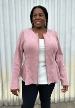Load image into Gallery viewer, Front view of a size 16 Lane Bryant baby pink suede zip-up corset-back jacket styled open over black pants on a size 14/16 model. The photo is taken outside in natural lighting.
