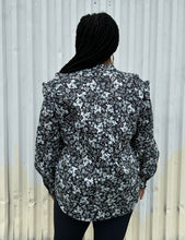 Load image into Gallery viewer, Back view of a size M (16/18) ERDEM x Universal Standard collab black, baby blue, and white floral high-necked button-up blouse with bishop sleeve on a size 14/16 model. The photo was taken outside in natural lighting.
