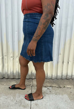 Load image into Gallery viewer, Side view of a size 16 ASOS medium wash denim pencil skirt styled with a rust-peach cropped tank and black flats on a size 14/16 model. The photo is taken outside in natural lighting.
