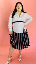Load image into Gallery viewer, Full-body front view of a size L TOME for 11 Honoré white, green, blue, red, and black mixed pinstripe and triple stripe collared button-up shirt dress with tie belt styled with white heels on a size 14/16 model.
