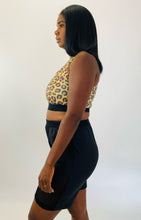 Load image into Gallery viewer, Side view of a size XXL Adam Selman yellow and brown leopard print sports bra styled with black mesh shorts on a size 12 model.
