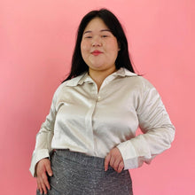 Load image into Gallery viewer, Front view of a size 14 Maria Cornejo for 11 Honoré off-white/cream collared button-up blouse styled with a gray textured skirt on a size 14/16 model.
