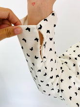 Load image into Gallery viewer, Close up detail shot of a missing button on the size 22 Monique Lhuillier for 11Honoré silky white gown with black mini butterfly print, choker and keyhole details, and puff sleeves.
