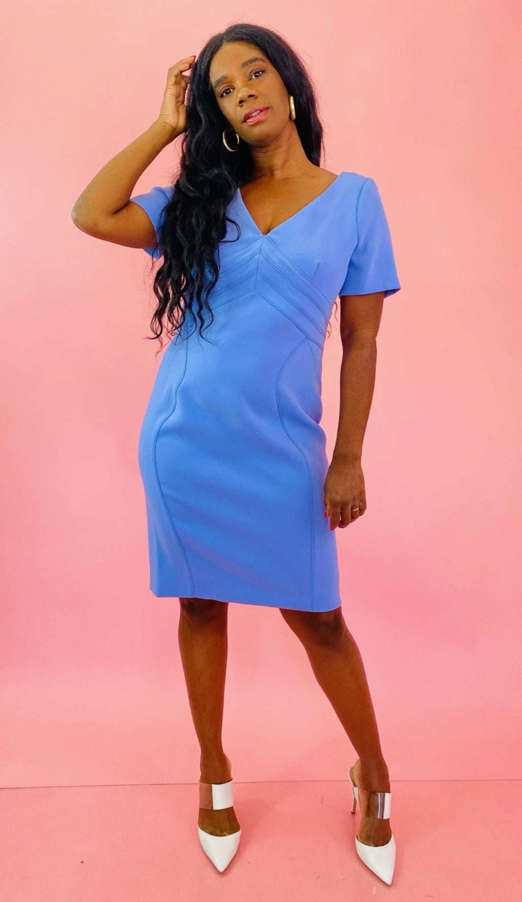 Full-body front view of a size 16 Zac Posen for 11 Honoré periwinkle blue v-neck short sleeve midi dress with pleated pattern styled with white heels on a size 10/12 model.