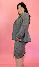 Load image into Gallery viewer, Side view showcasing the black fringe unfinished hem of a size 18 Lela Rose gray tweed, textured blazer and skirt 2-piece suit set with black unfinished fringe hem styled with an off-white button-up top on a size 14/16 model.
