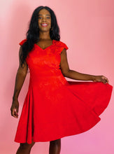Load image into Gallery viewer, Front view of a size 14 Zac Posen for 11 Honoré vibrant red floral burnout pattern a-line midi dress with cap sleeves and burnout stripe hem on a size 10/12 model.

