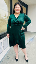 Load image into Gallery viewer, Full-body front view of a size 16 Bloomchic green velvet midi dress with tulip hem and long sleeves styled with black pumps on a size 14/16 model.
