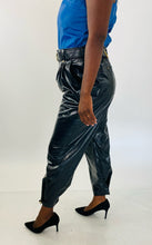 Load image into Gallery viewer, Side view of these sexy size 14 Tanya Taylor black pleather high waisted tapered trousers with belt and gold hardware styled with a blue pleather tank and black pumps on a size 12 model.
