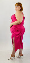 Load image into Gallery viewer, Full-body side view of a size 22 Pretty Little Thing hot pink strappy midi dress with a high side slit and structured boning at the bust styled with white heels on a size 22 model.
