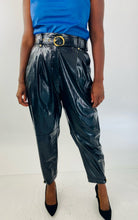 Load image into Gallery viewer, Front view of these sexy size 14 Tanya Taylor black pleather high waisted tapered trousers with belt and gold hardware styled with a blue pleather tank and black pumps on a size 12 model.
