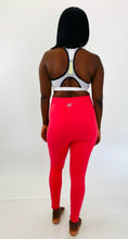 Load image into Gallery viewer, Full-body back view of a pair of size L fbf salmon pink active leggings styled with a white and black sports bra on a size 12 model.
