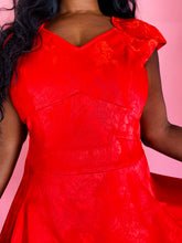 Load image into Gallery viewer, Closer view of the bodice of a size 14 Zac Posen for 11 Honoré vibrant red floral burnout pattern a-line midi dress with cap sleeves and burnout stripe hem on a size 10/12 model.
