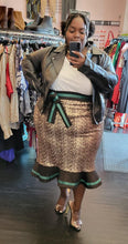 Load image into Gallery viewer, Additional full-body front view of a size 26 Eloquii gold sequin maxi skirt with black and green ruffle hem and waist detail styled with a white collared shirt under a black leather jacket and heels on a size 22/24 model.
