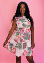 Load image into Gallery viewer, Closer front view of a size 14 Monique Lhuillier for 11 Honoré white lace a-line mini dress with pink and green floral pattern, a high neck, and a voluminous skirt on a size 12 model.
