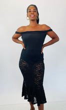 Load image into Gallery viewer, Front view of this Fashion to Figure size 1 off-the-shoulder black bodysuit maxi dress with black lace overlay and mermaid-style skirt on a size 12 model.
