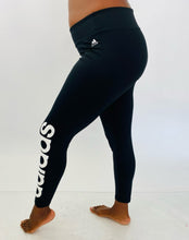 Load image into Gallery viewer, Side view of a pair of size XL Adidas black active leggings with the &quot;Adidas&quot; logo down the side on a size 12 model.
