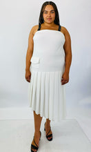 Load image into Gallery viewer, Additional full-body front view of a size 16 Jamie Wei Huang white asymmetrical hem midi dress with pleated skirt, pocket details, and faux leather straps styled with strappy black heels on a size 18/20 model.
